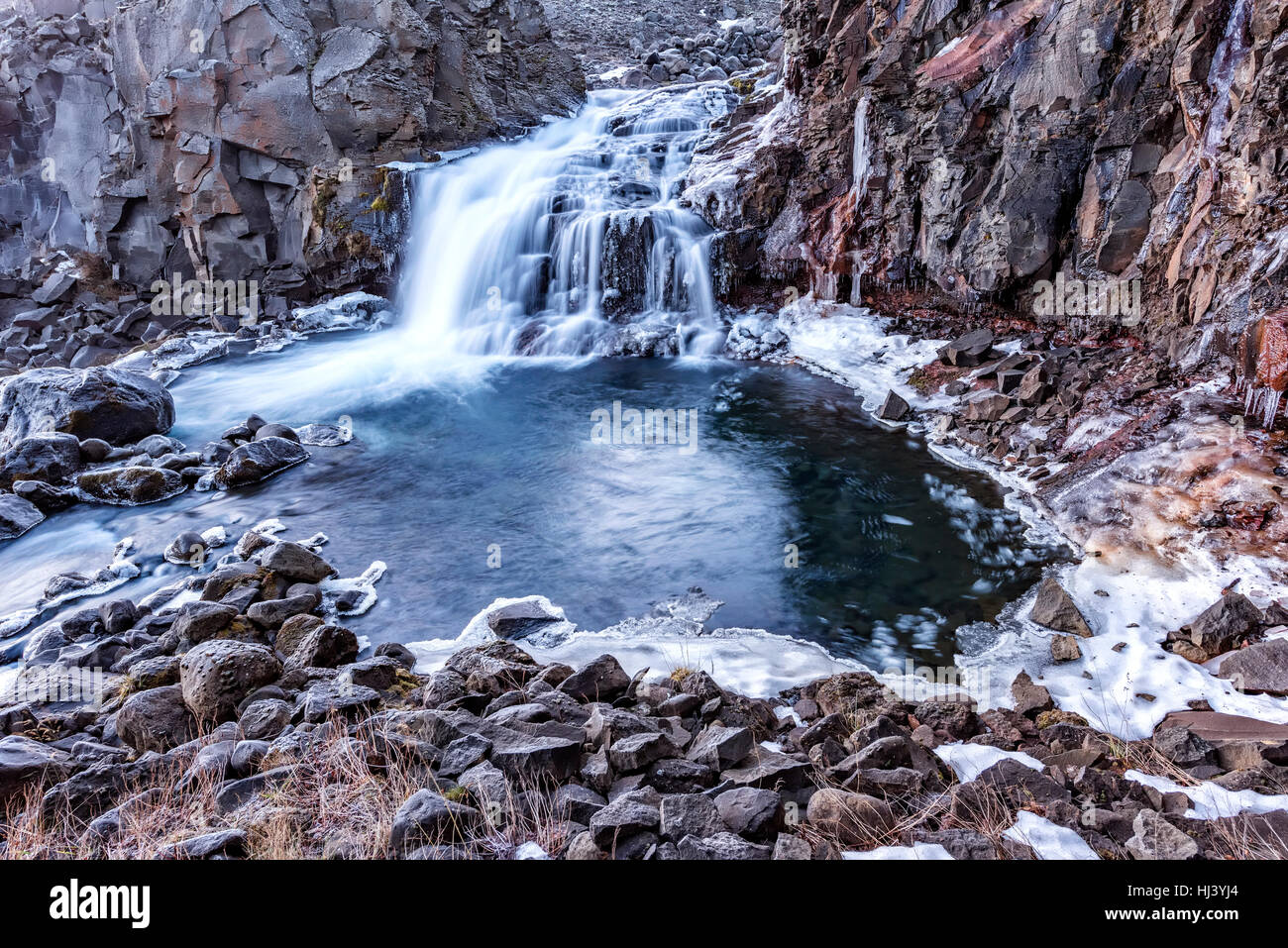 Une cascade en Islande cascades en bas du côté d'une montagne sauvage dans une piscine naturelle. Banque D'Images