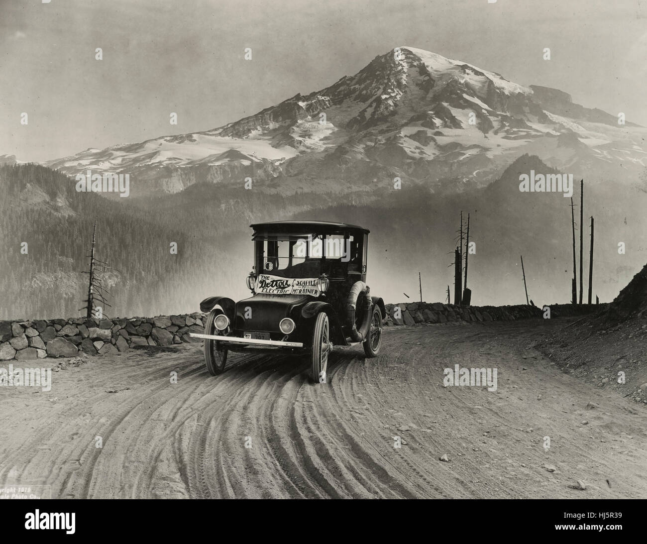Detroit Electric auto sur tournée promotionnelle à travers les montagnes de Seattle à Mt. Rainier. La photographie montre la voiture électrique produite pour Anderson Voiture électrique Co. avec Mt. Rainier dans la distance. 1919 Banque D'Images