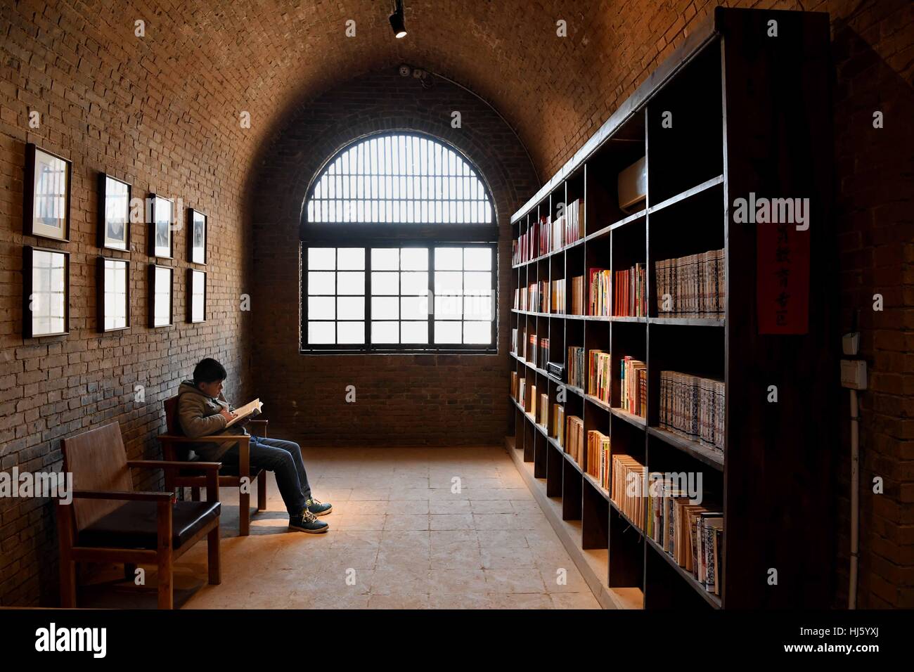 (170122) -- BEIJING, 22 janvier 2017 (Xinhua)-- un enfant lit des livres à un habitat troglodytique dans bibliothèque Mogou Village de Mengzhou Ville, Centre de la Chine, la province du Henan, le 19 janvier 2017. L'habitat troglodytique bibliothèque, couvrant une superficie d'environ 4 000 mètres carrés, comprend plus de 50 000 volumes. Il est ouvert au public gratuitement. (Xinhua/Li Un) Banque D'Images