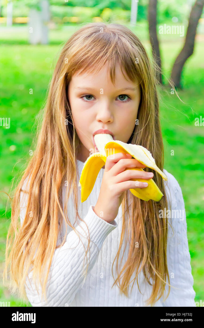 Photo de fille mangent la banane en été Banque D'Images