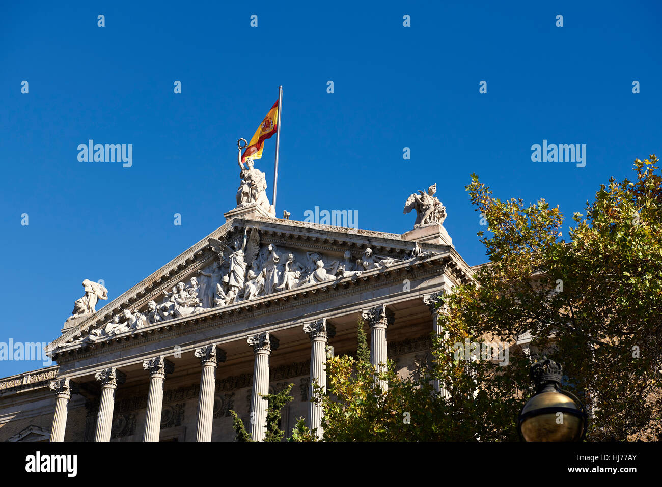 Drapeau espagnol sur le toit de la Bibliothèque Nationale, Paseo de Recoletos, Madrid, Espagne. L'Europe, l'architecture et l'art Banque D'Images