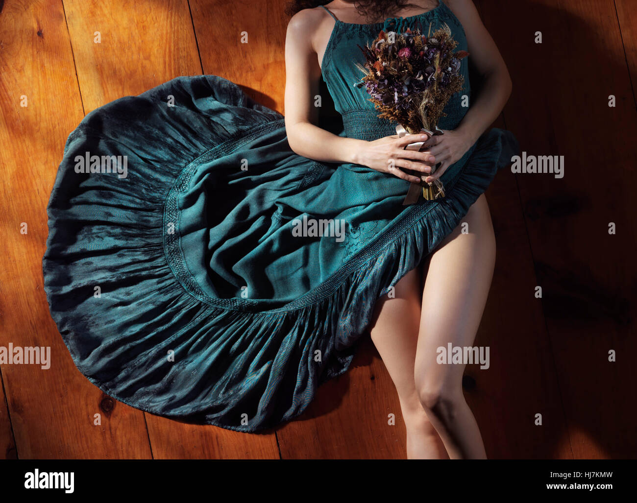 Licence disponible à MaximImages.com - Portrait abstrait artistique Sensual d'une femme dans une robe bleu bohème avec des jambes nues couché sur le sol avec Banque D'Images