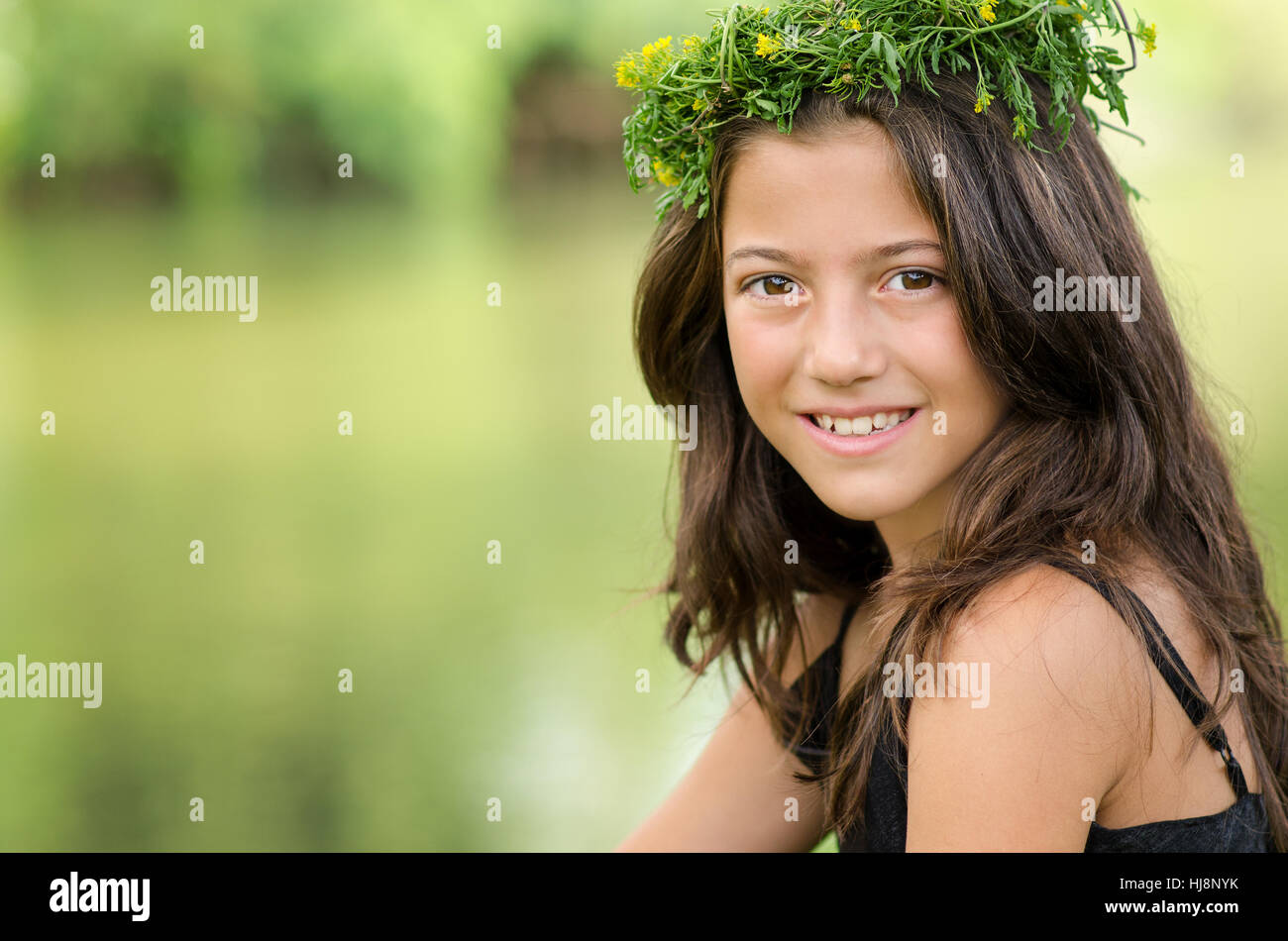 Portrait of a smiling girl portant une couronne de fleurs sur la tête. Banque D'Images