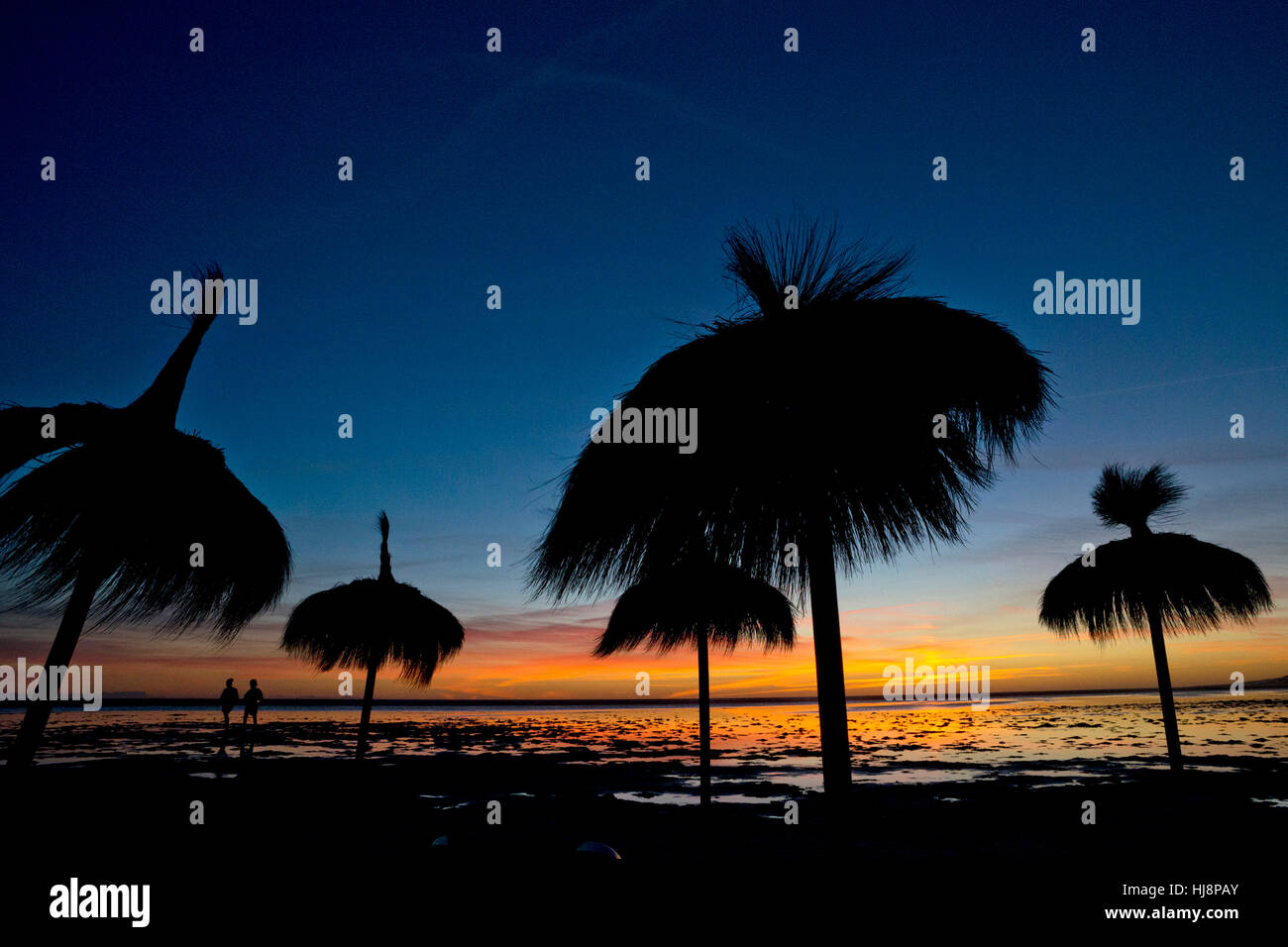 Silhouette de deux personnes et des parasols sur la plage de Los Lances, Tarifa, Cadix, Espagne, Andaulcia Banque D'Images