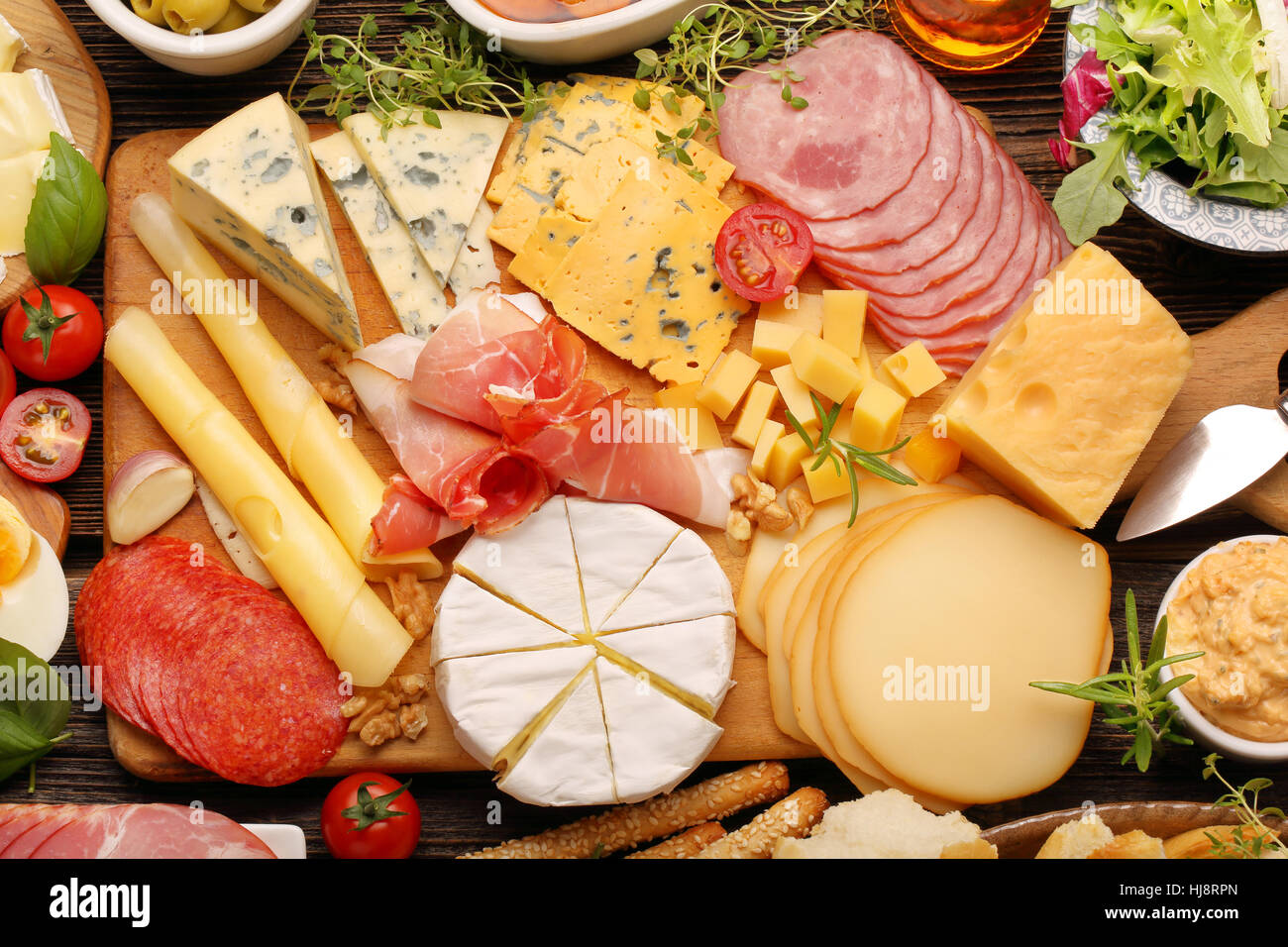Buffet de différents types de fromage et des hors-d'établir sur planche de bois rustique Banque D'Images