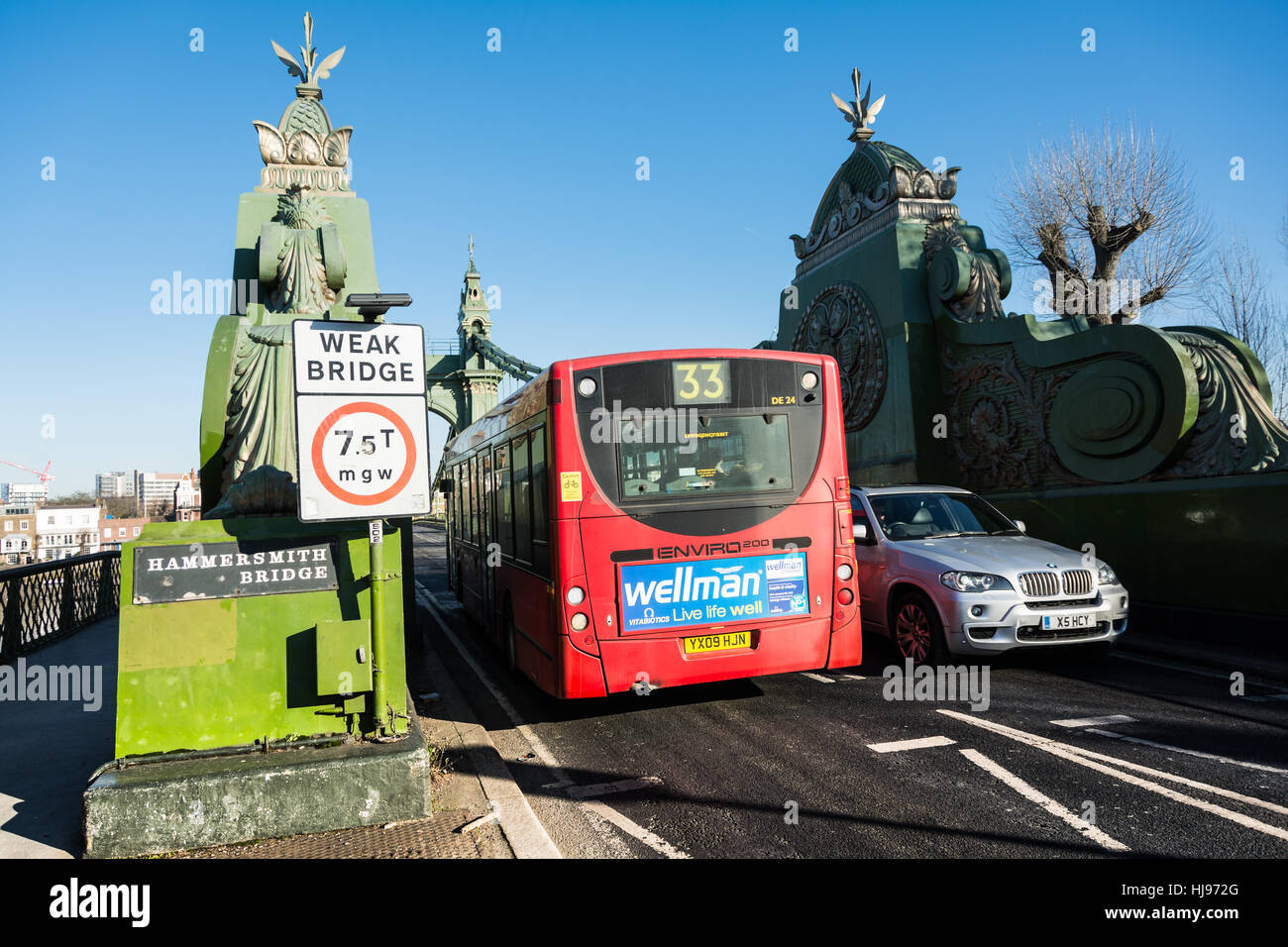 Voitures et bus passant un signe de pont faible sur Hammersmith Bridge à l'ouest de Londres, Angleterre, Royaume-Uni. Banque D'Images