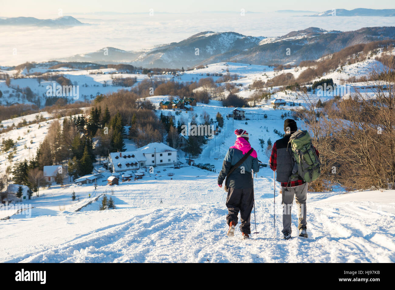 Couple de randonneurs marche sur la colline de neige Banque D'Images