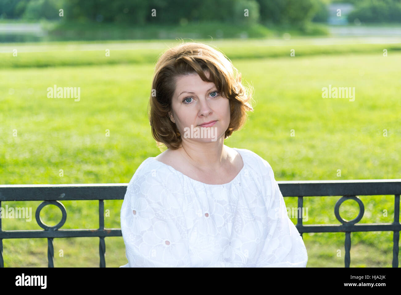 Femme sombre dans le parc sur un banc Banque D'Images