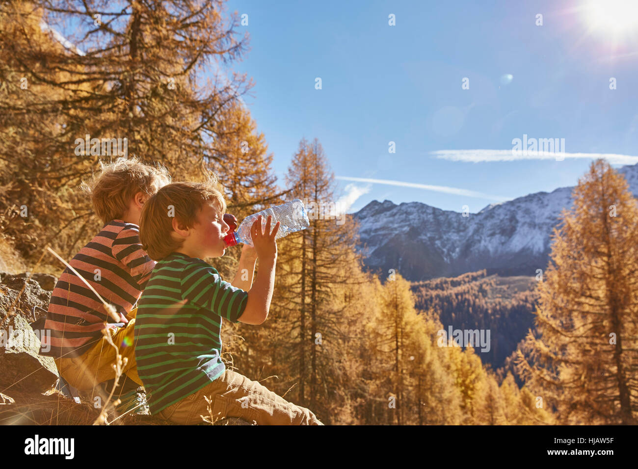 Deux garçons assis sur des rochers, des bouteilles d'eau potable, de Schnalstal, Tyrol du Sud, Italie Banque D'Images