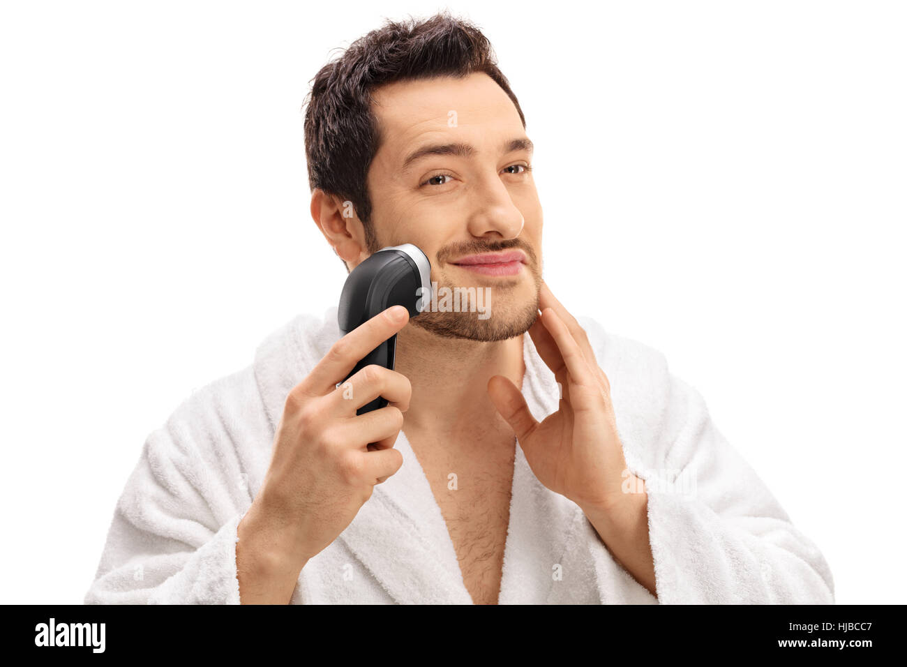 Beau mec sa barbe de fraisage avec un rasoir électrique isolé sur fond blanc Banque D'Images