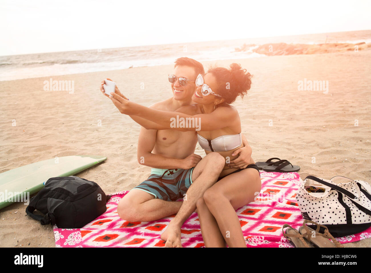 Couple selfies smartphone sur Rockaway Beach, New York State, USA Banque D'Images
