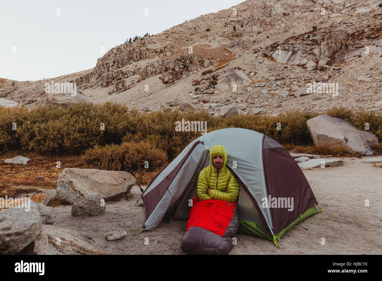 Portrait of male hiker assis par tente, minéral King, Sequoia National Park, Californie, USA Banque D'Images