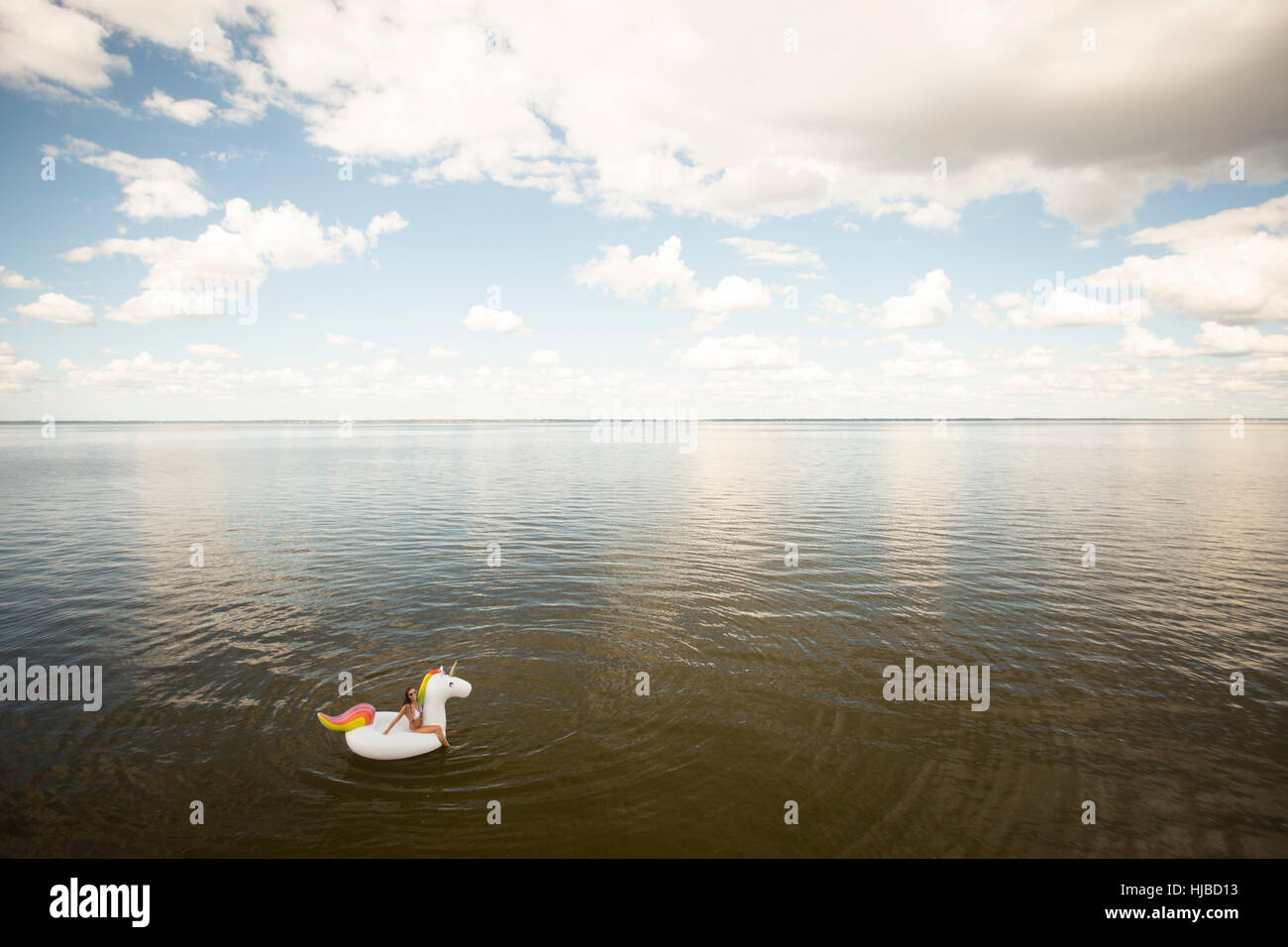 High angle vue lointaine de jeune femme assise sur la mer, en licorne gonflable Santa Rosa Beach, Florida, USA Banque D'Images