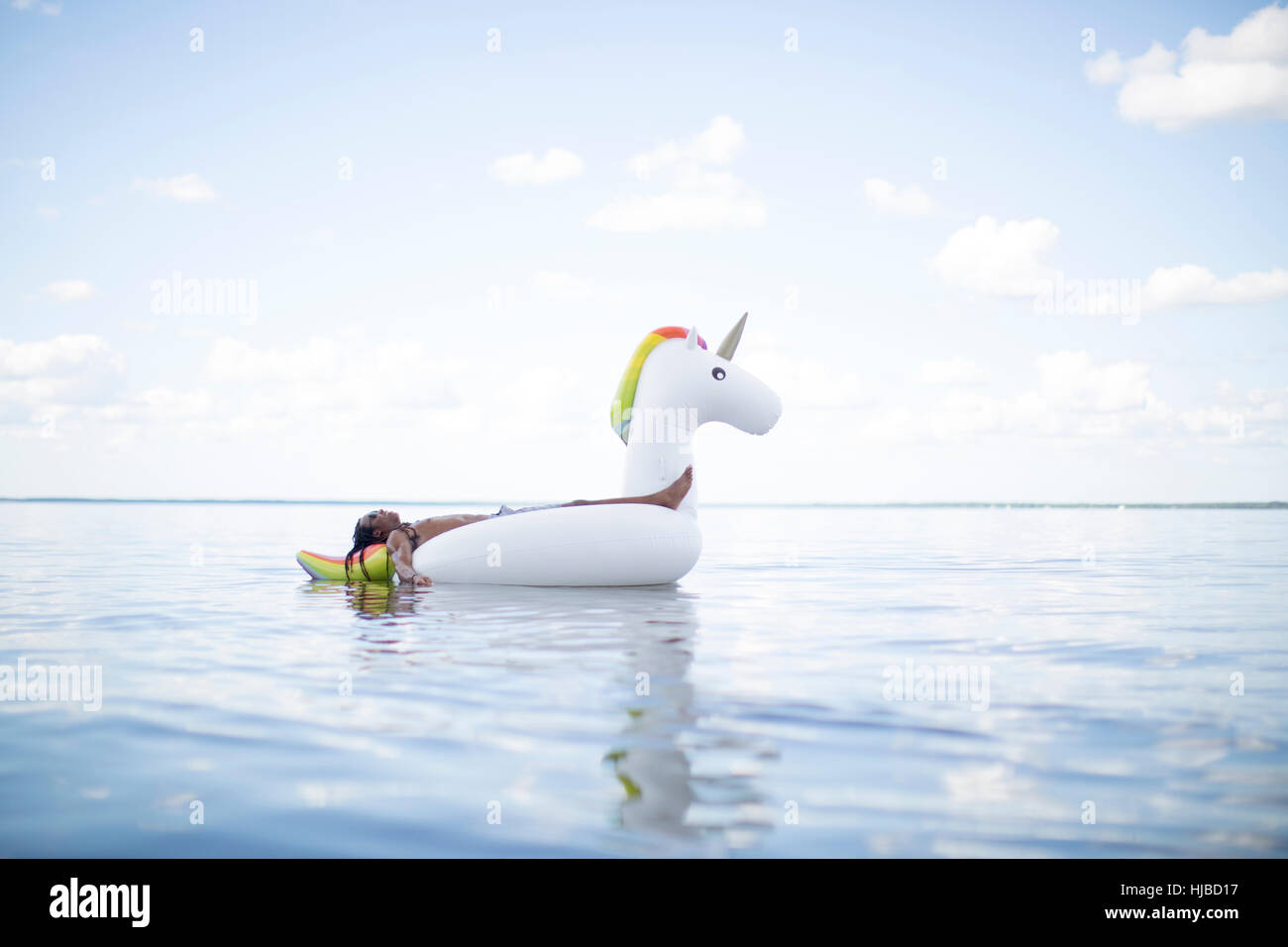 Jeune homme sur la mer, en licorne gonflable Santa Rosa Beach, Florida, USA Banque D'Images