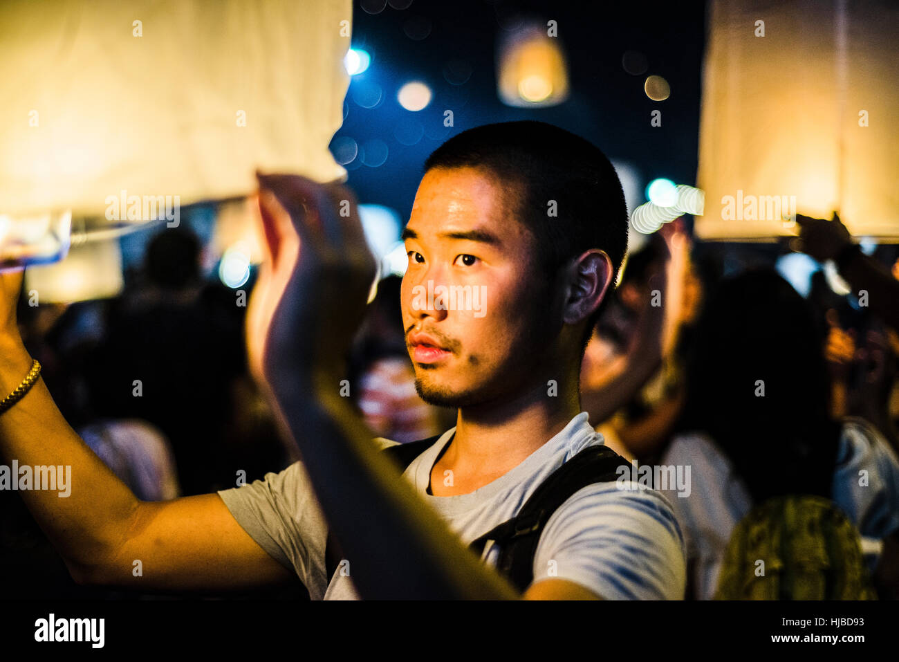 Jeune homme tenant allumée lanterne de papier en attente de libération à papier Loy Krathong Festival à Chiang Mai, Thaïlande Banque D'Images
