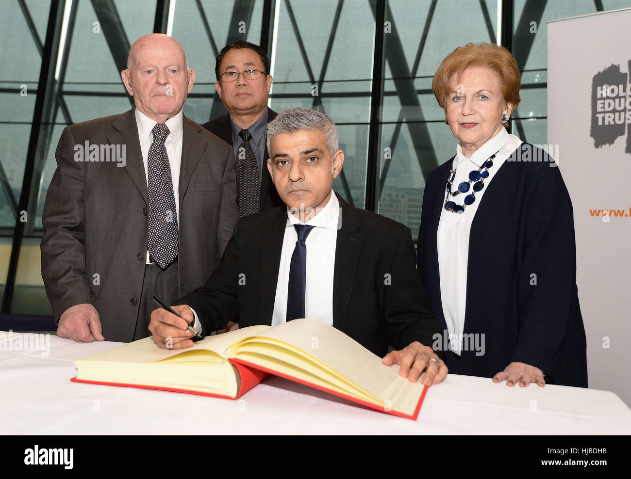 Maire de Londres Sadiq Khan (deuxième à droite) et les survivants de l'Holocauste (de gauche à droite) Ben Helfgott, Sokphal et Mala Tribich Din, signer un livre de souvenir après une journée commémorative de l'Holocauste à l'Hôtel de ville de Londres. Banque D'Images