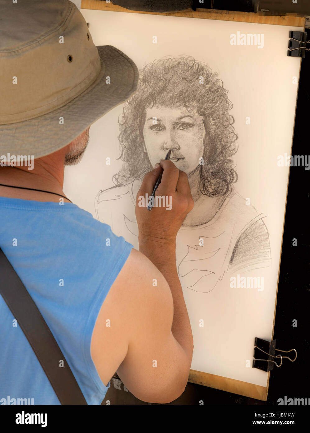 Artiste de rue, au travail, l'élaboration d'un portrait d'une jolie femme avec des cheveux bouclés, sur le Pont Charles, Prague 1, République tchèque. Banque D'Images