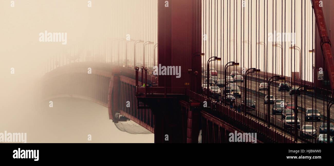 Les pays émergents et le trafic entrant dans le brouillard tôt un matin froid à travers le Golden Gate Bridge San Francisco, États-Unis Banque D'Images