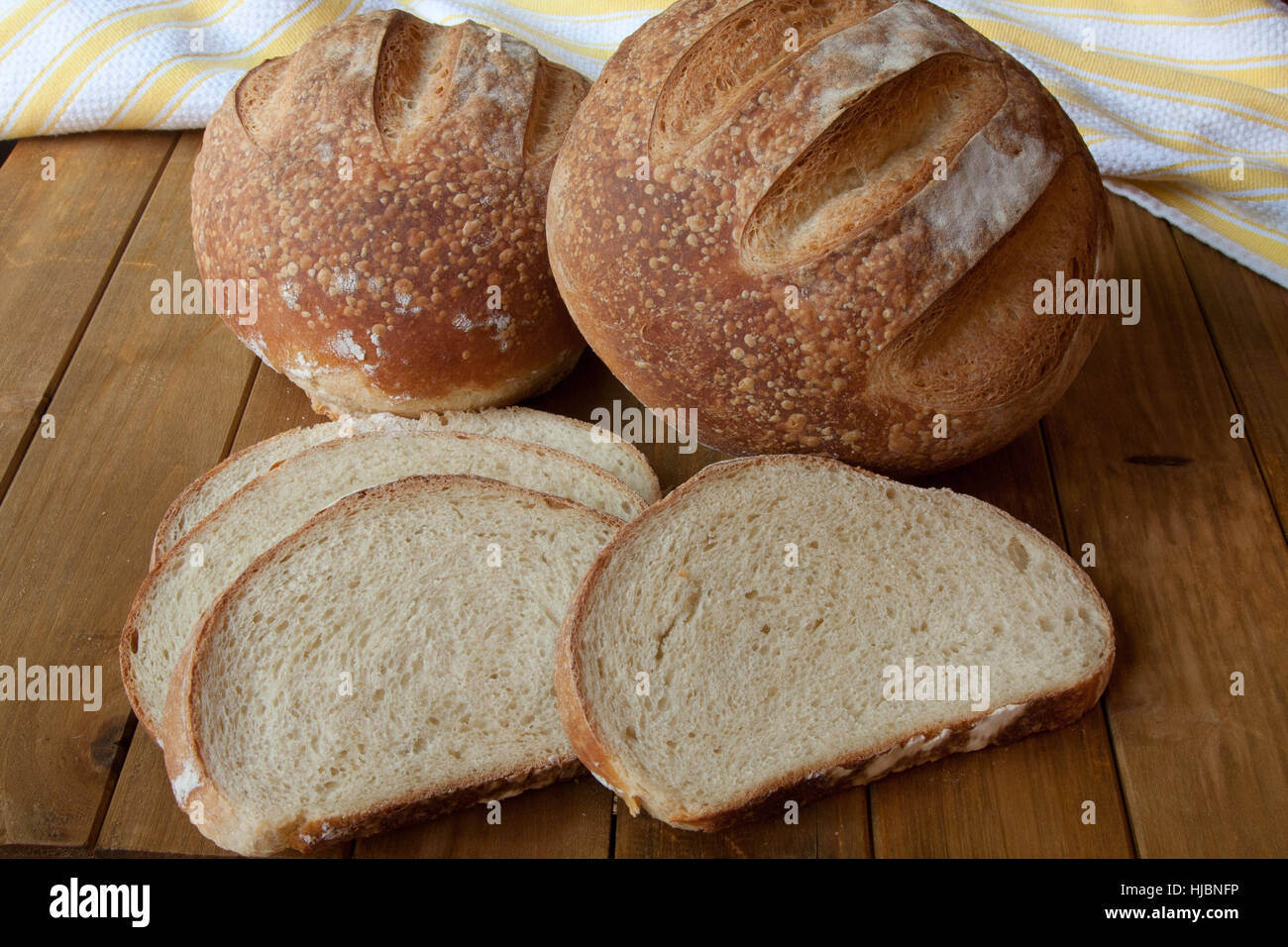 Deux pains de tranches de pain sur une surface en bois avec un torchon dans l'arrière-plan Banque D'Images