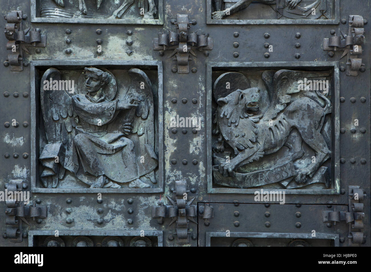 L'homme ailé de Saint Matthieu et le lion ailé de Saint Marc. Détail de la porte de bronze de la Basilique de la Santa Cruz (Basilique de la Sainte Croix) dans le Valle de los Caidos (vallée de l'armée déchue) près de Madrid, Espagne. Banque D'Images