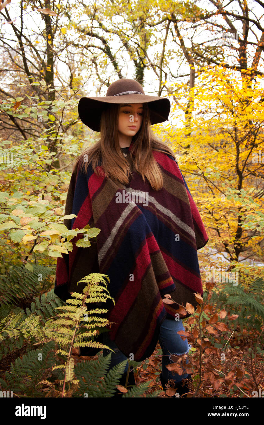 Young woman standing in a forest in autumn entouré de jolies couleurs automnales Banque D'Images