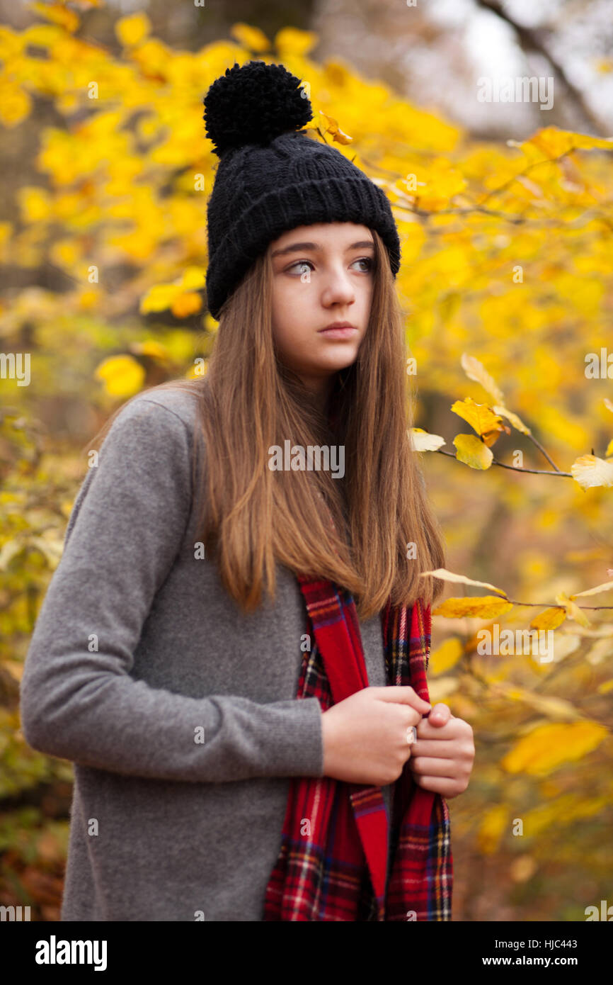 Pretty young girl wearing woolen hat avec couleurs automnales en arrière-plan à la recherche dans la distance Banque D'Images