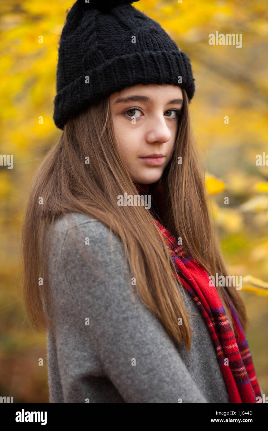Portrait d'une jolie adolescente à tout droit à l'appareil photo avec des couleurs automnales en arrière-plan Banque D'Images