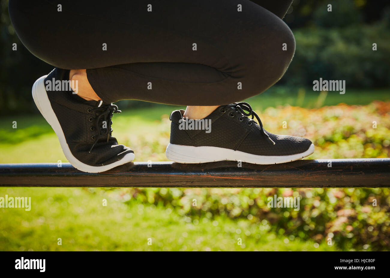 Formation Femme, jambes et pieds en équilibre sur park fence Banque D'Images