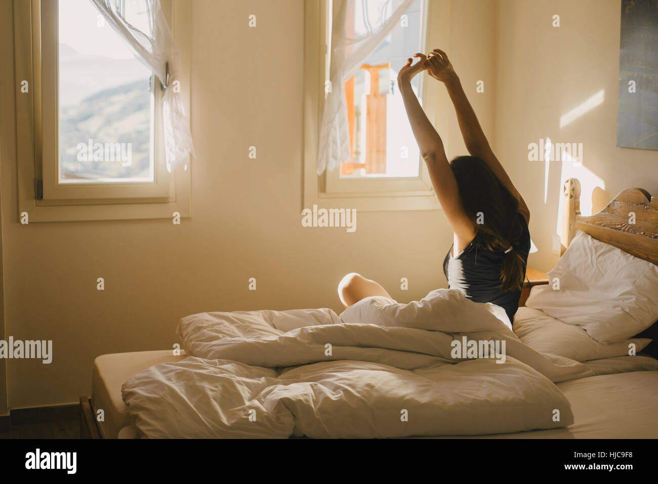 Woman stretching in bed Banque D'Images