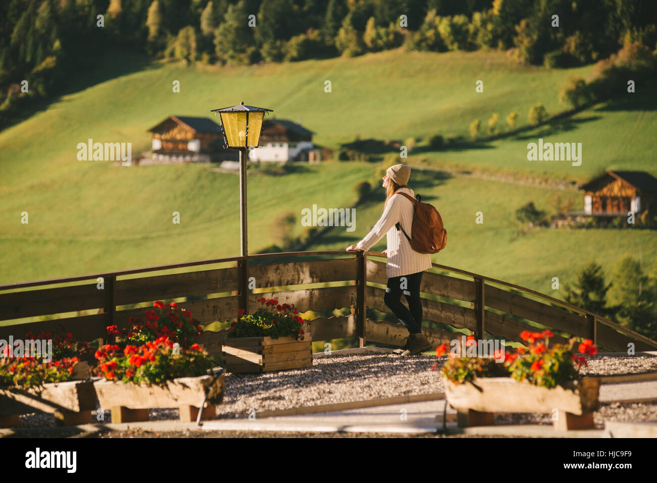 Woman enjoying view par clôture en bois, Santa Maddalena, Cols Alpins, Val di Funes (Funes Valley), le Tyrol du Sud, Italie Banque D'Images