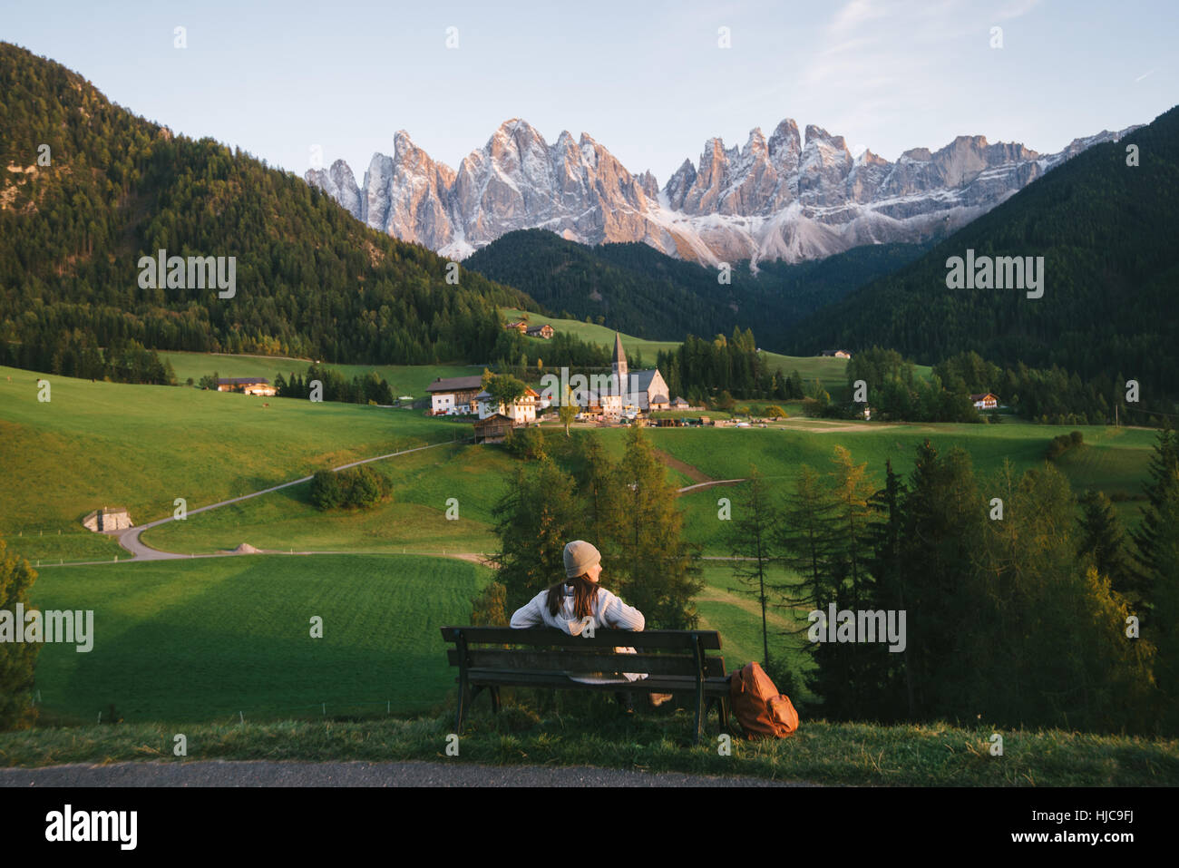 Woman relaxing on park bench, Santa Maddalena, Cols Alpins, Val di Funes (Funes Valley), le Tyrol du Sud, Italie Banque D'Images