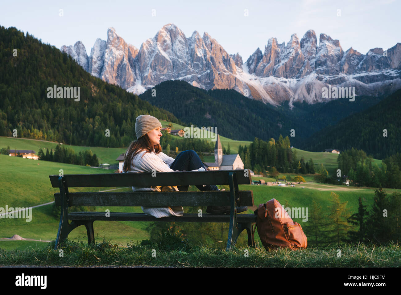 Woman relaxing on park bench, Santa Maddalena, Cols Alpins, Val di Funes (Funes Valley), le Tyrol du Sud, Italie Banque D'Images