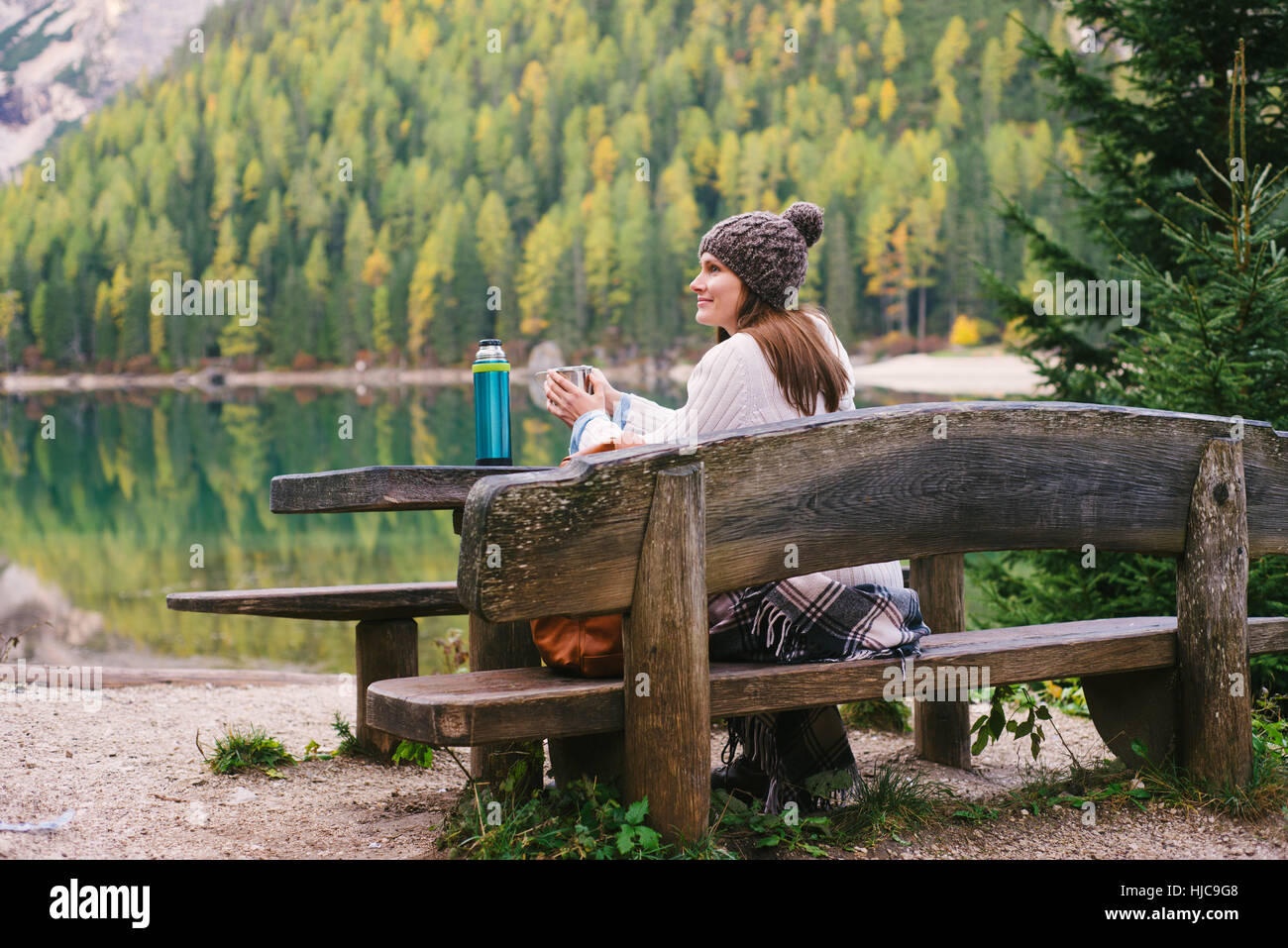 Woman relaxing on park bench, Lago di Braies, Cols Alpins, Val di Braies, Tyrol du Sud, Italie Banque D'Images