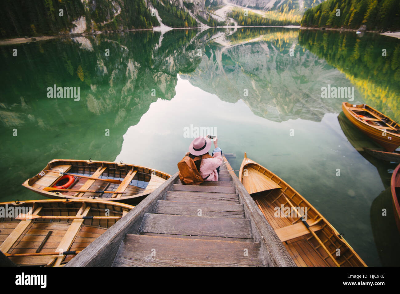 Woman relaxing on pier, Lago di Braies, Cols Alpins, Val di Braies, Tyrol du Sud, Italie Banque D'Images