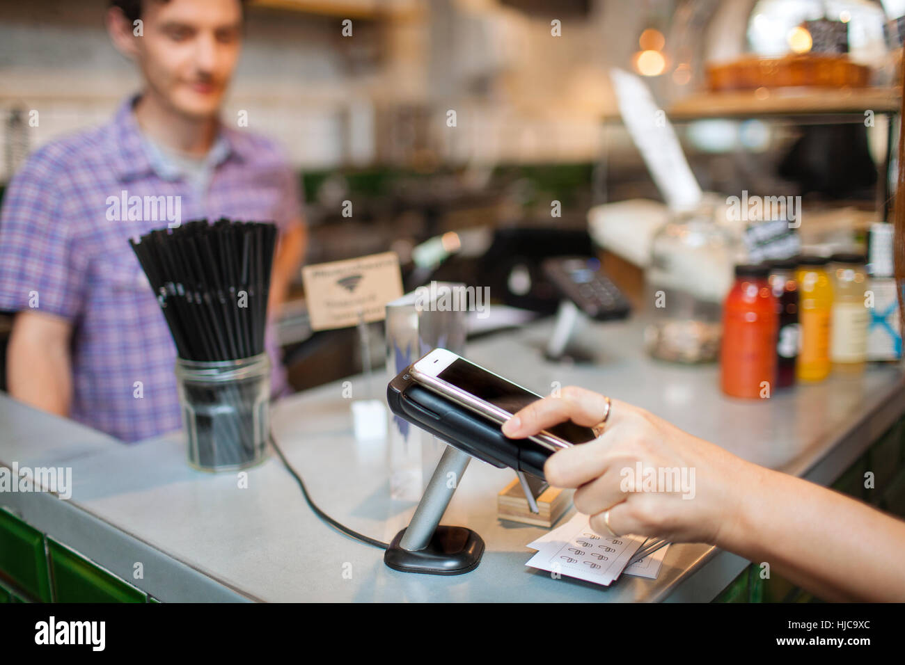 Cropped shot of female client utilisant le paiement sans contact smartphone in cafe Banque D'Images