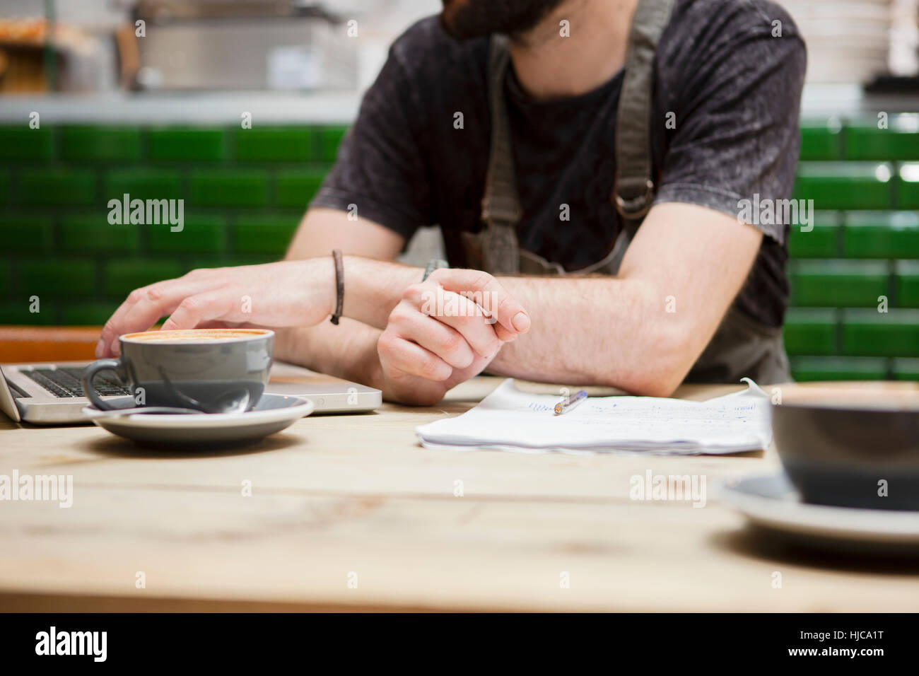 Cropped shot of male cafe owner doing paperwork at table Banque D'Images