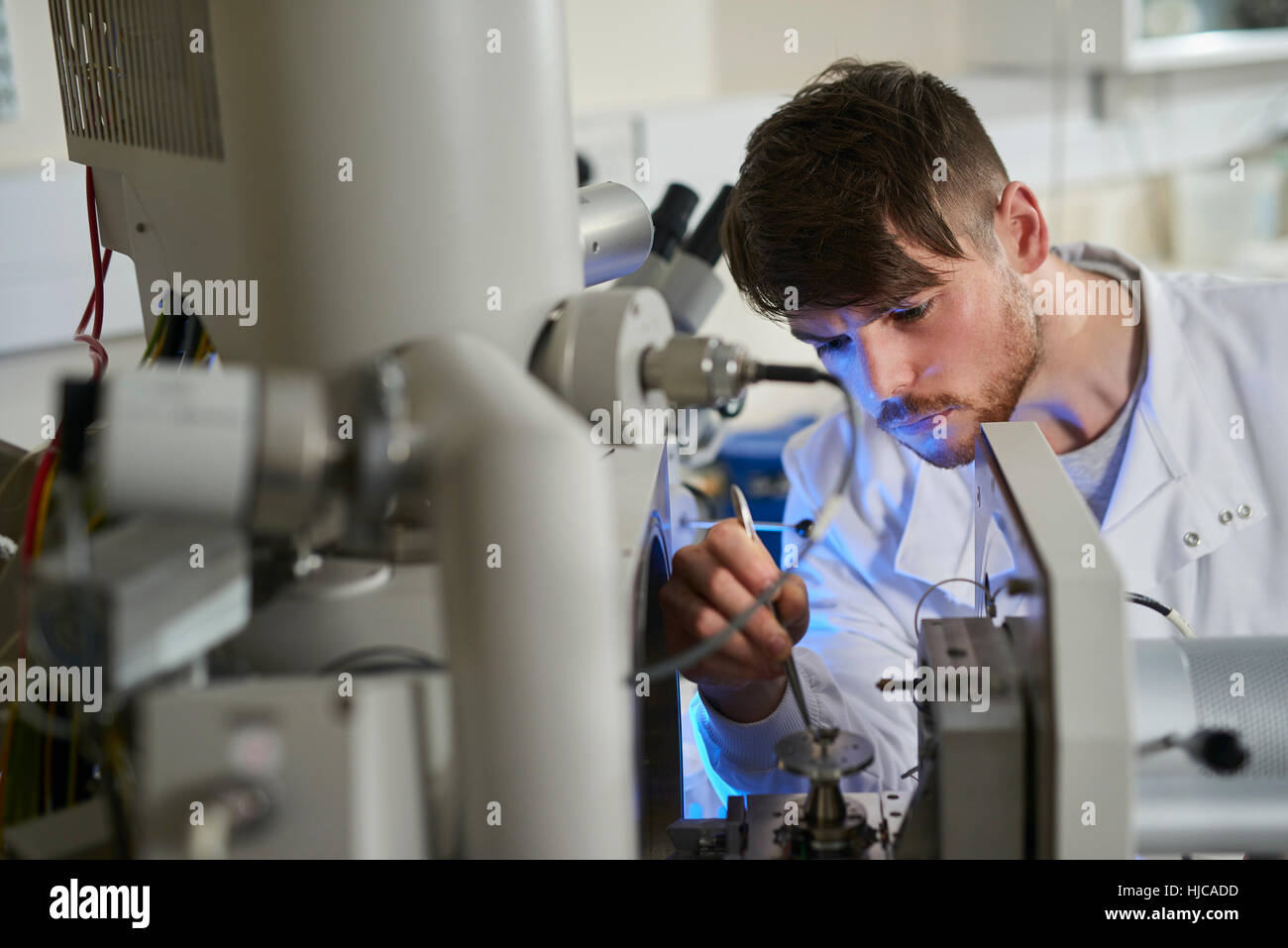 Les scientifiques de l'objet placé sur le matériel scientifique à l'aide de pincettes Banque D'Images