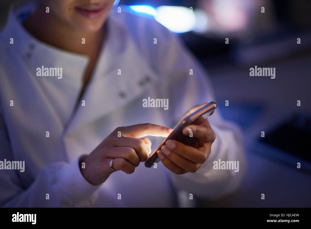 Scientist in laboratory texting on smartphone Banque D'Images