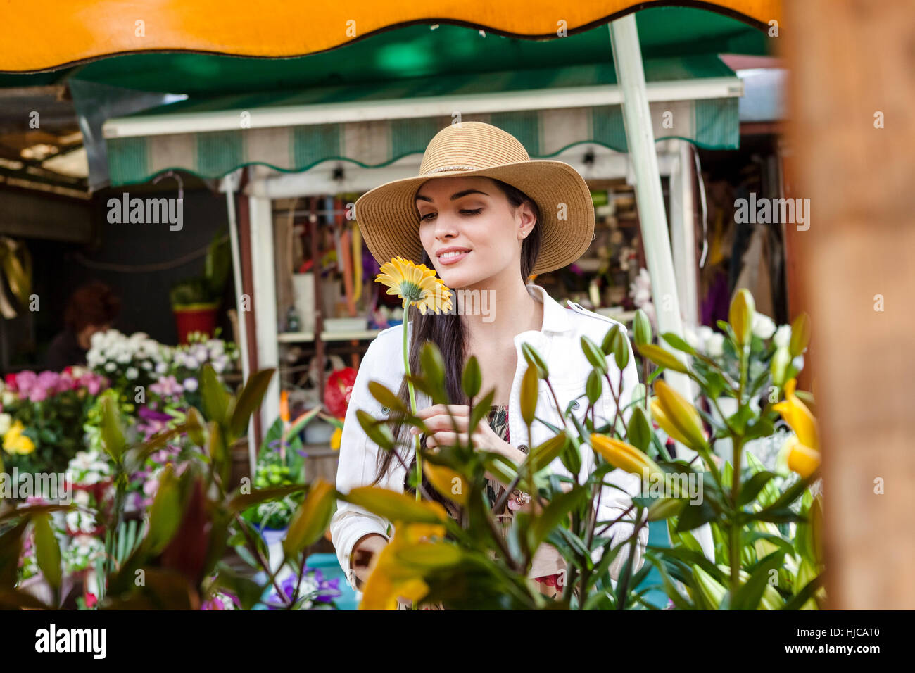 Young Woman smelling flowers on market stall, Split, Dalmatie, Croatie Banque D'Images