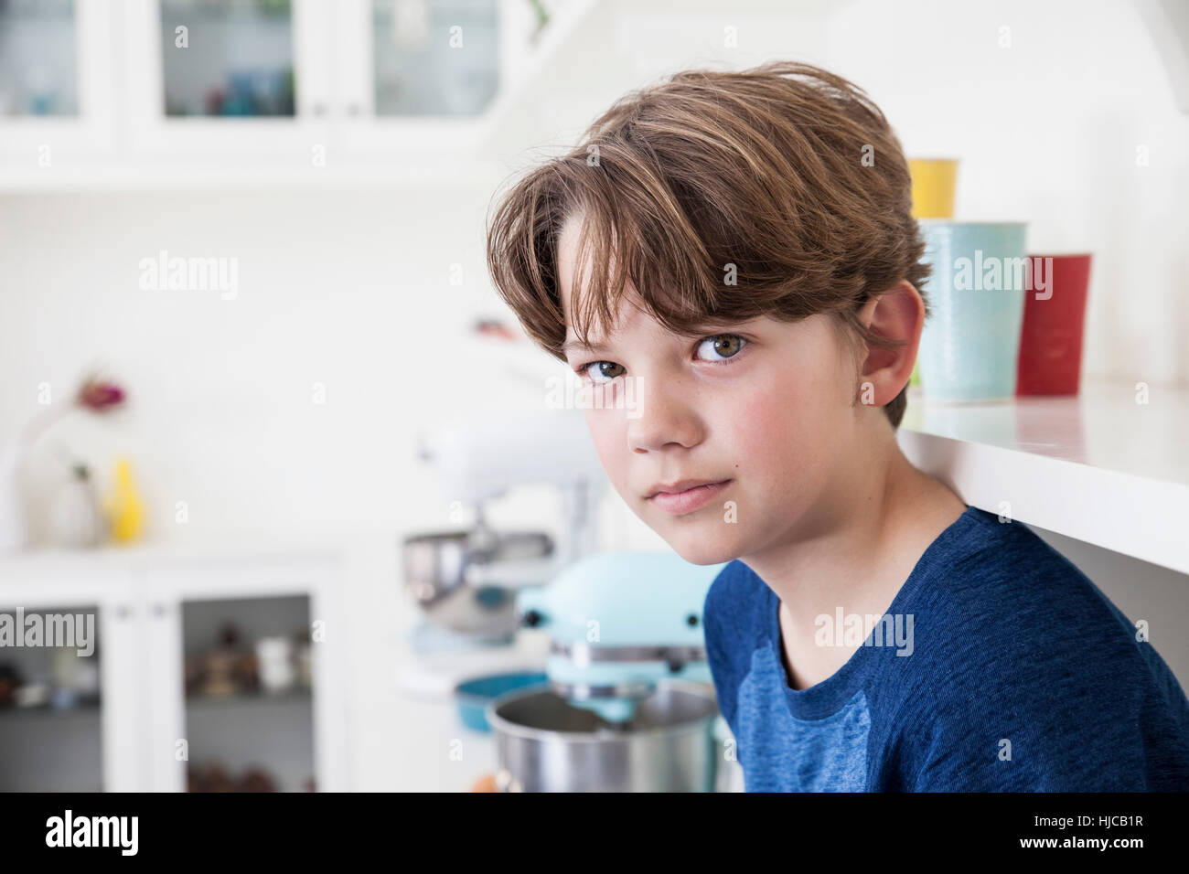 Portrait de garçon assis sur une surface de travail de cuisine Banque D'Images