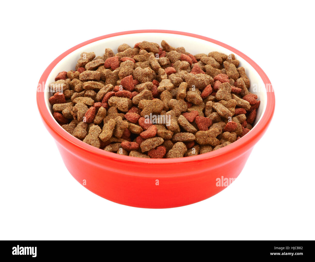 Biscuits secs pour chats rouge dans un bol d'aliments pour animaux de compagnie, isolé sur fond blanc Banque D'Images
