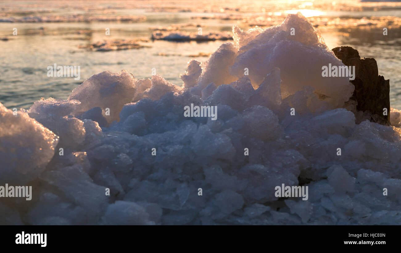 La glace sur le fleuve dans les rayons du soleil couchant Banque D'Images