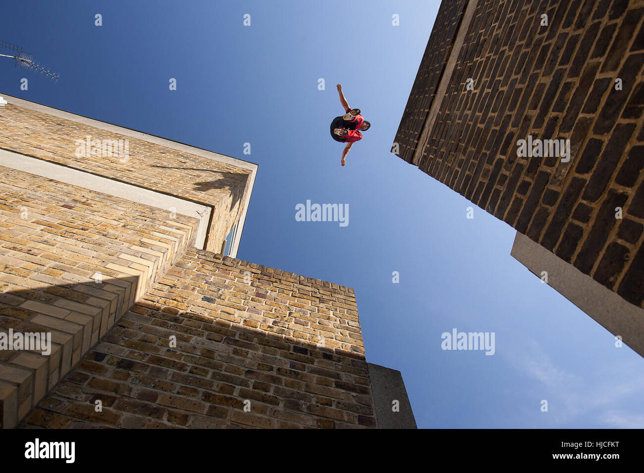 Un homme faisant parkour, sautant de toit en toit Banque D'Images