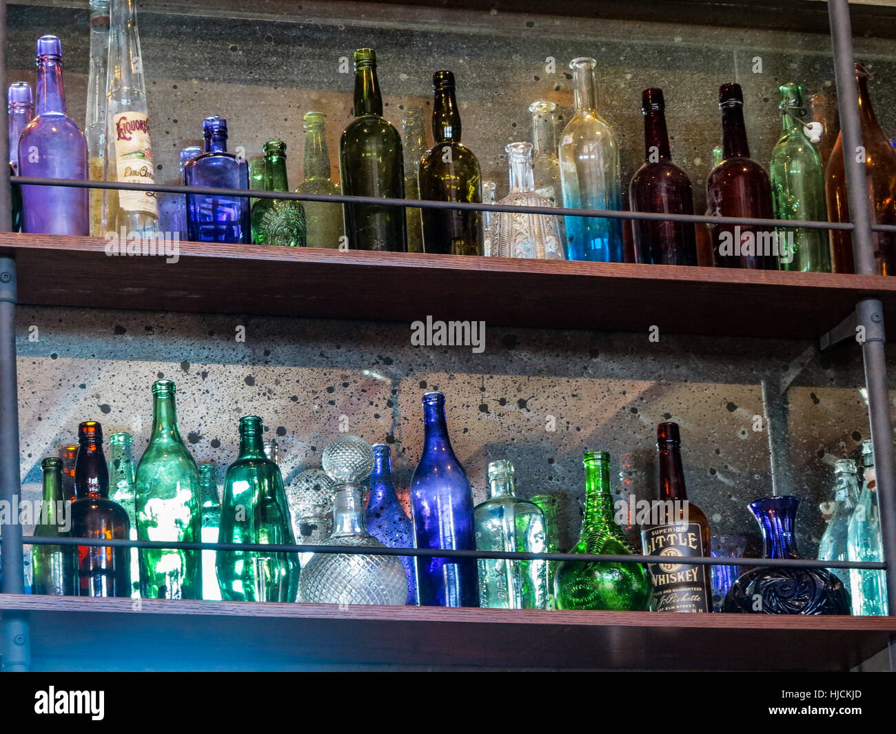 Beaucoup de bouteilles en verre de différentes couleurs sur des étagères. Banque D'Images