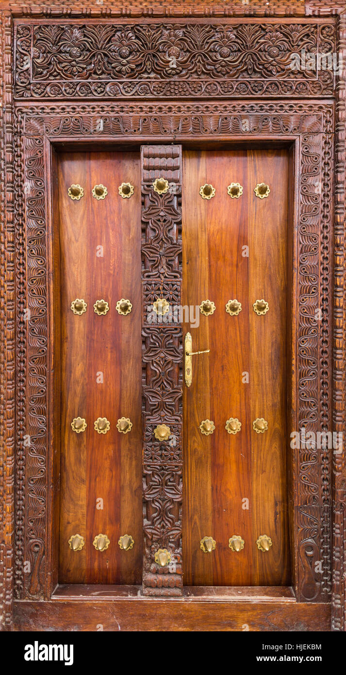 Décorées en bois et portes de maison riche brun jaune avec metal clous laiton, Arabe conception, Stone Town, Zanzibar, Tanzania, Africa Banque D'Images