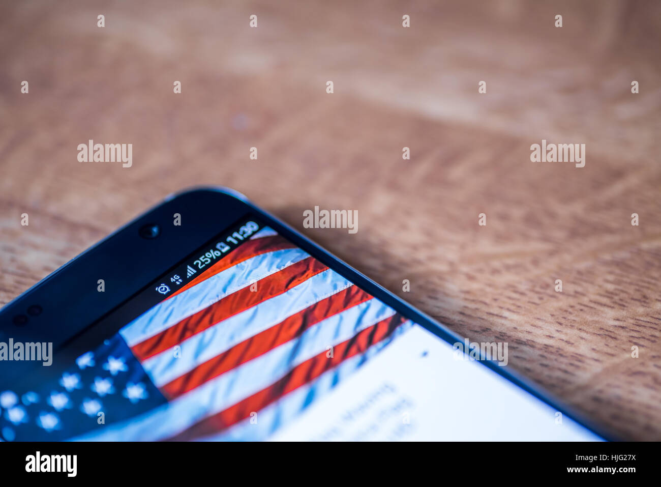 Smartphone sur fond de bois avec 4G Réseau inscription 25  % et USA drapeau sur l'écran. Banque D'Images