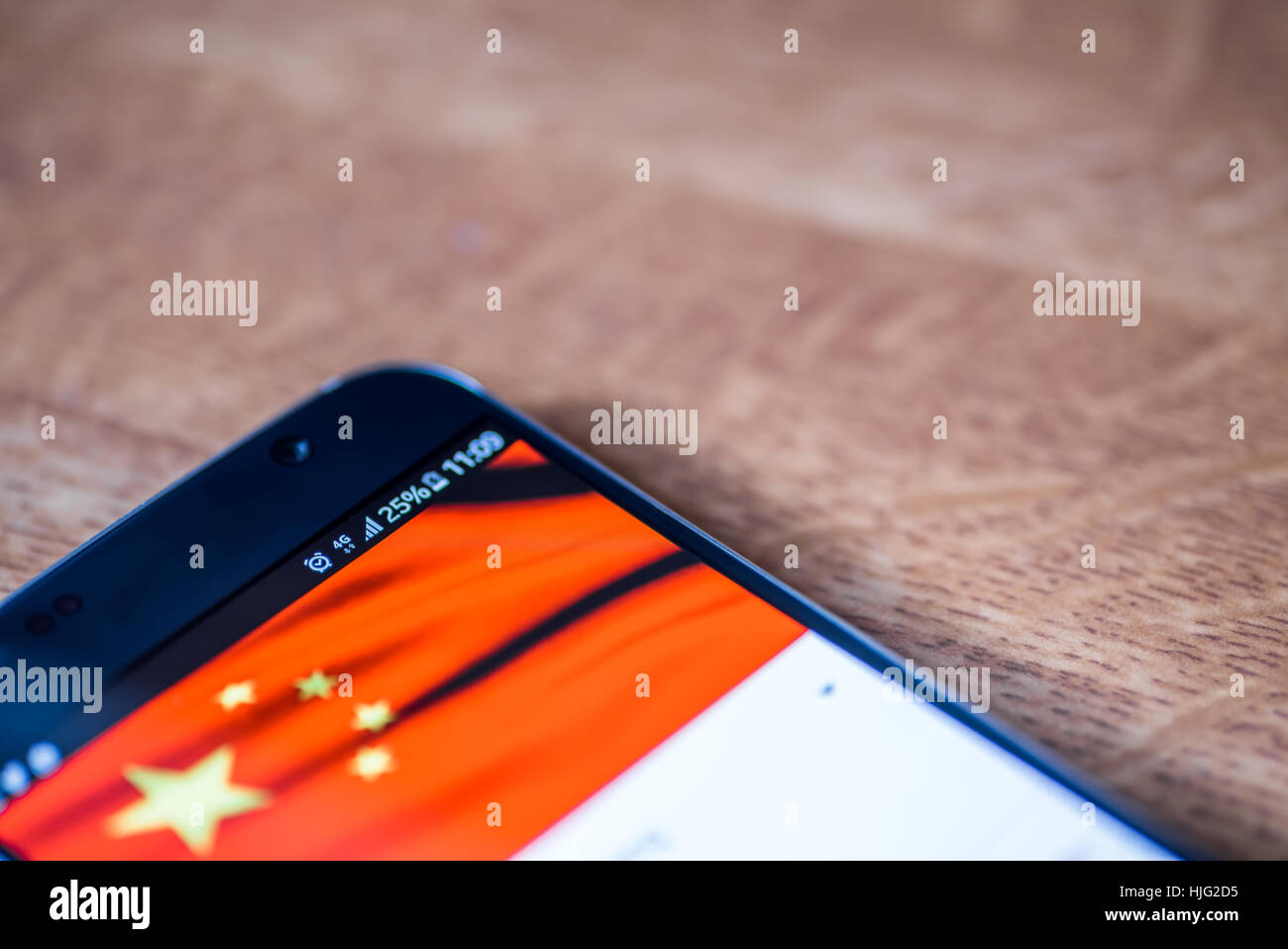 Smartphone sur fond de bois avec 4G Réseau inscription 25  % et la Chine drapeau sur l'écran. Banque D'Images