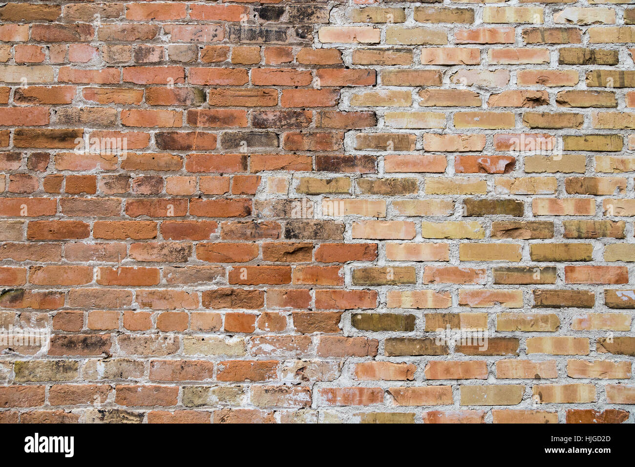 Un vieux mur de briques avec deux couleurs différentes de brique mélange. Banque D'Images