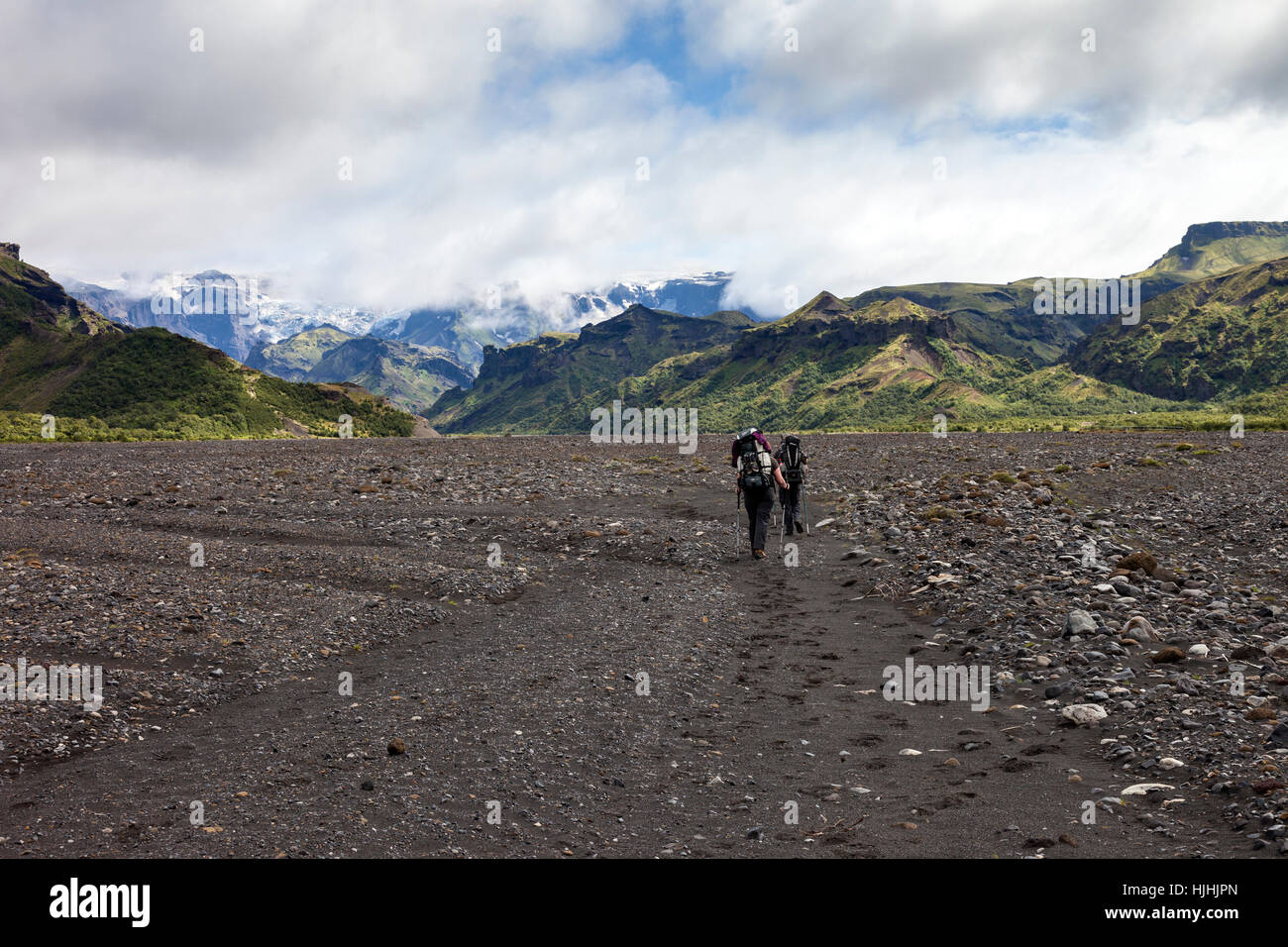 Les randonneurs traversent la plaine inondable de la rivière Krossa avec le Myrdalsjokull, sous l'avant de la calotte glaciaire qui se trouve le volcan Katla, Islande Banque D'Images