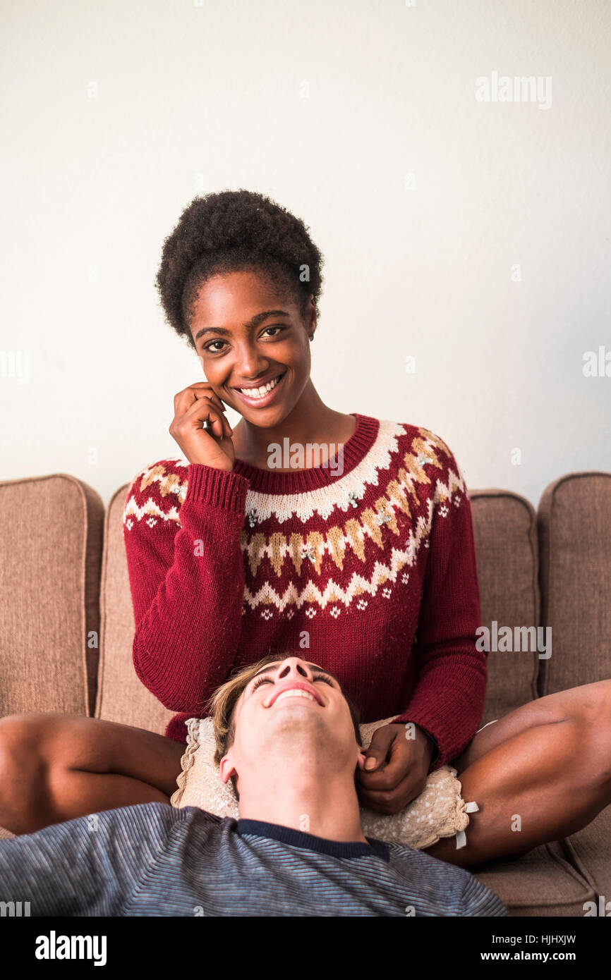 Portrait of young woman relaxing avec son petit ami dans la salle de séjour Banque D'Images